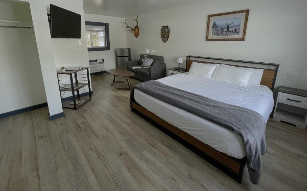 Sacajawea Inn في Salmon: غرفة نوم بسرير كبير وكرسي