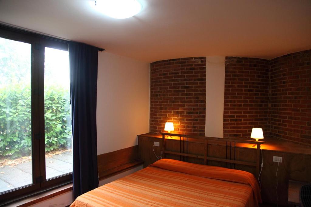ein Schlafzimmer mit einem Bett und einem großen Fenster in der Unterkunft Tiberio in Loro Ciuffenna