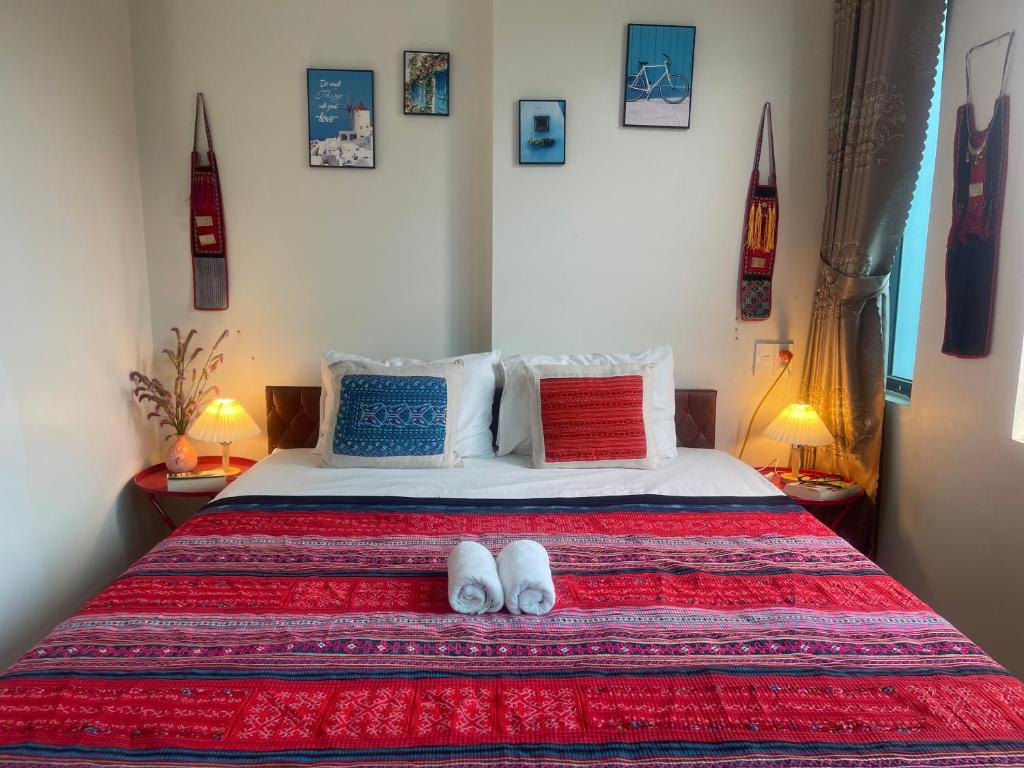 a bedroom with a bed with two slippers on it at Ha Giang Yolo House and Loop Tours in Ha Giang