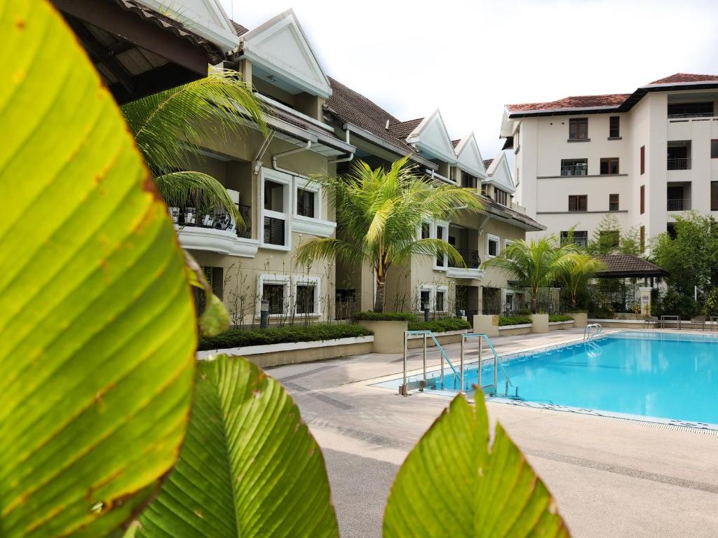 A resort swimming pool surrounded by landscaped buildings and palm trees.
