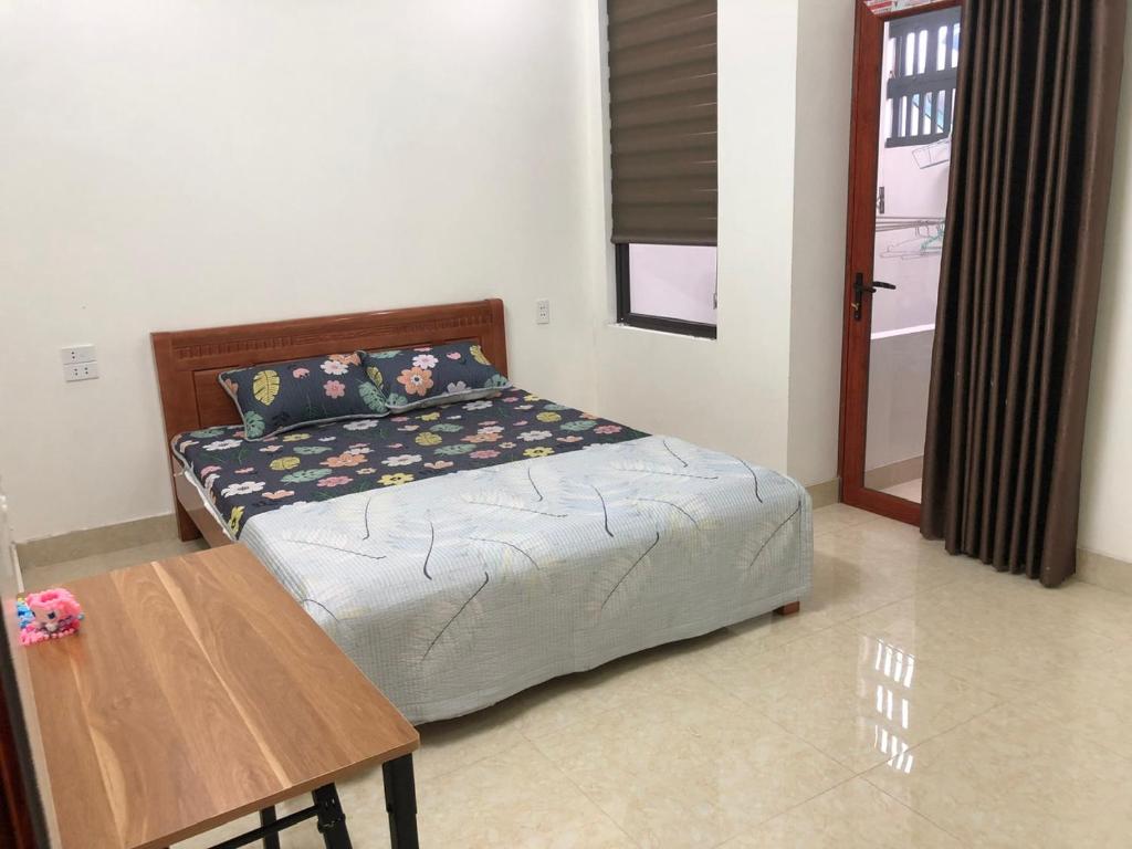 Schlafzimmer mit einem Bett und einem Holztisch in der Unterkunft Thảo Nguyên Homestay in Lạng Sơn