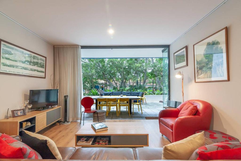 ein Wohnzimmer mit einem Sofa, einem TV und einem Tisch in der Unterkunft Sterling 1 Self-Catering in Sydney