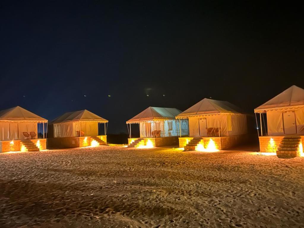 a row of tents in a field at night at Heritage Luxury Camp in Sām
