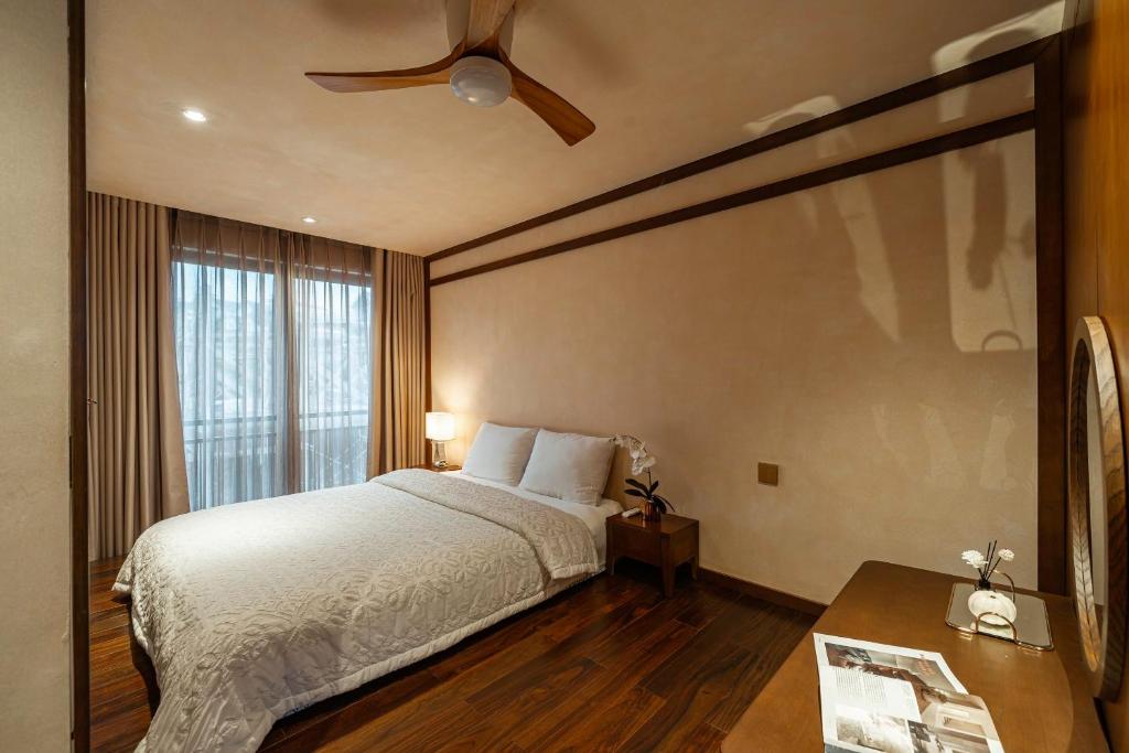een slaapkamer met een bed en een plafondventilator bij Biệt Thự Nam Hồ Đà Lạt - Villa Luxury Nam Hồ in Khu Chi Lăng