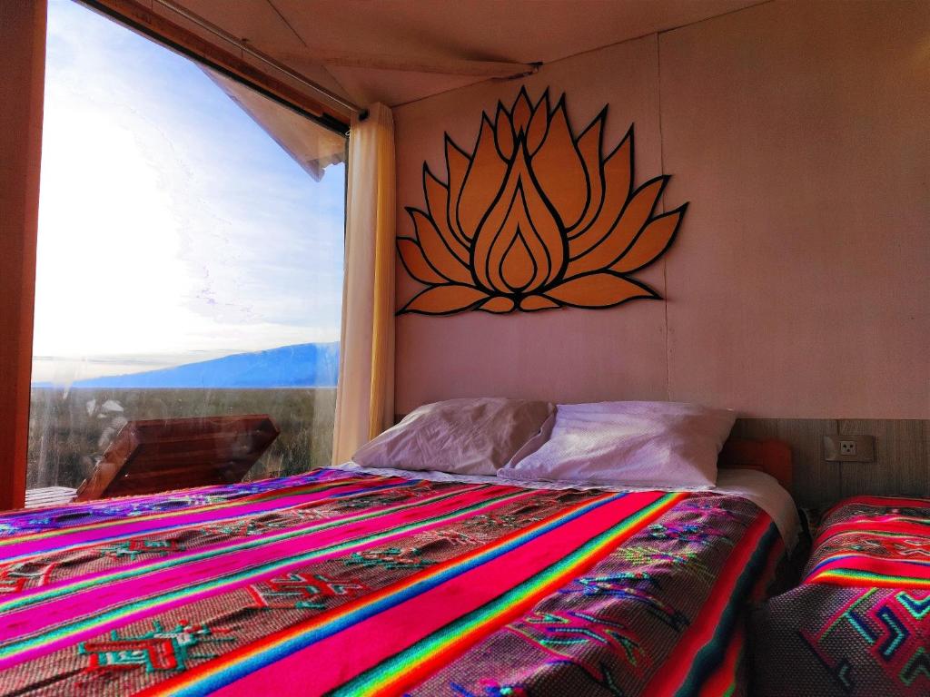 1 dormitorio con 1 cama con una pintura en la pared en Titicaca Vista amanecer, en Puno