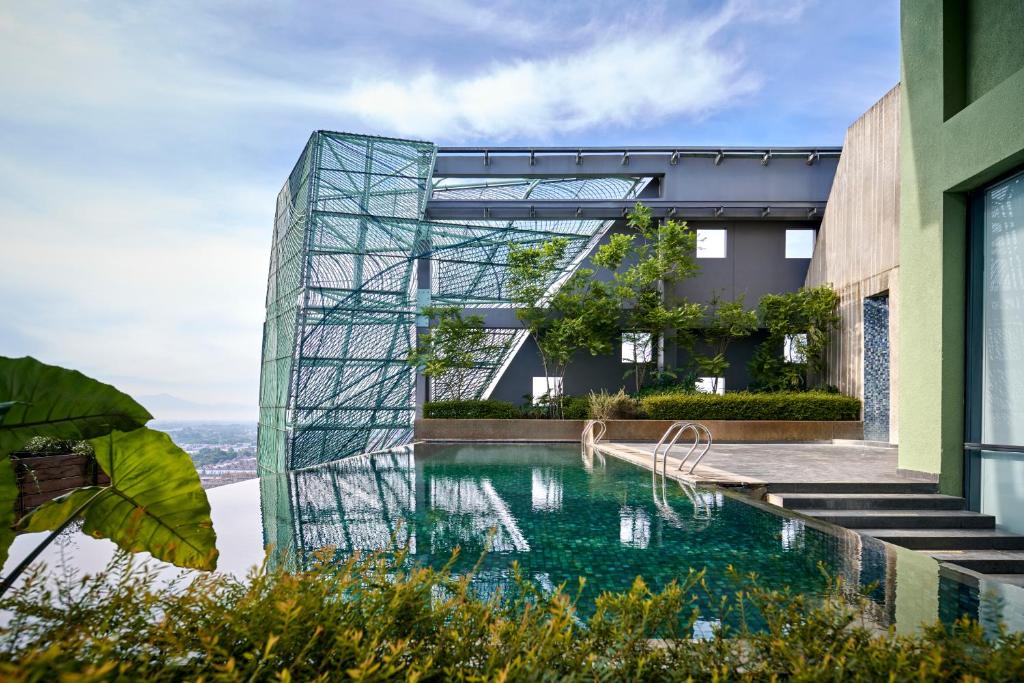 une maison en verre avec une piscine en face de celle-ci dans l'établissement VIVERE Hotel, ARTOTEL Curated, à Tangerang