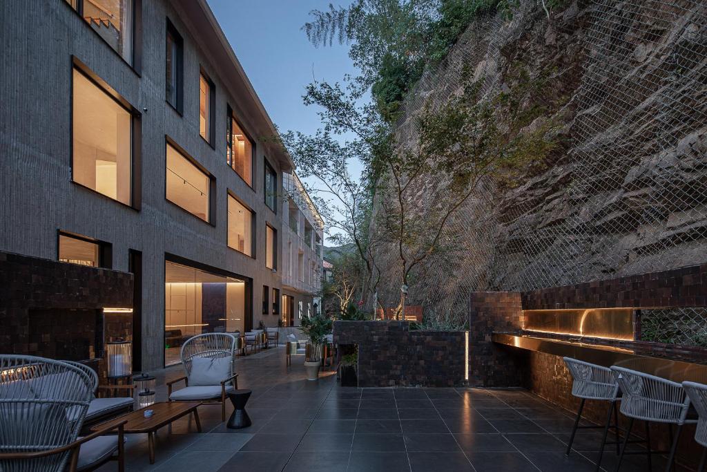 a patio with tables and chairs next to a building at Tingjian Twenty-three Bay Rock Wall Private Soup Designer Homestay in Yixing