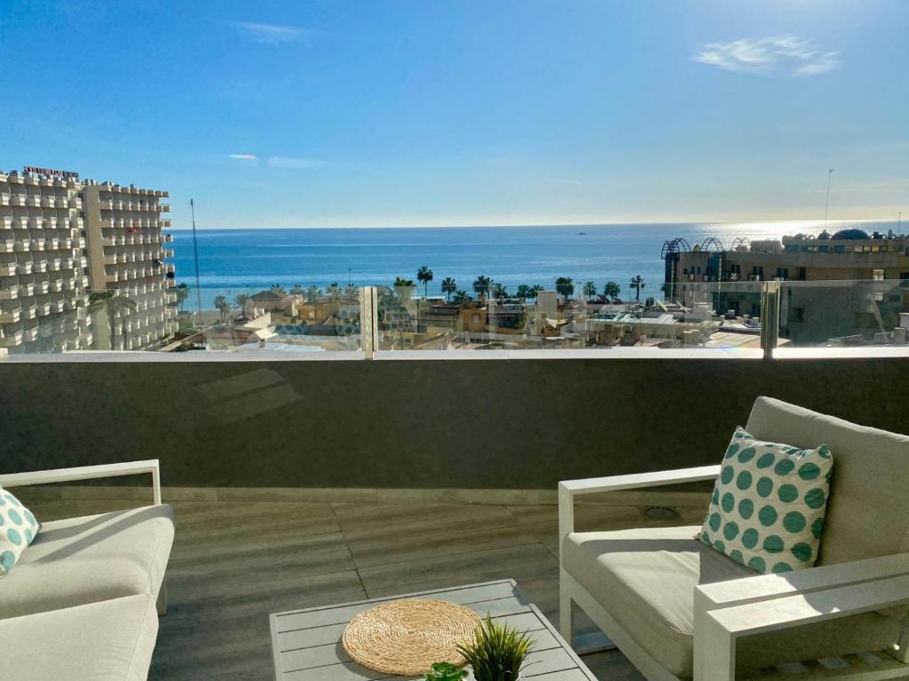 Un balcón con sillas y vistas al océano. en APARTAMENTO CON VISTAS AL MAR, en Torremolinos