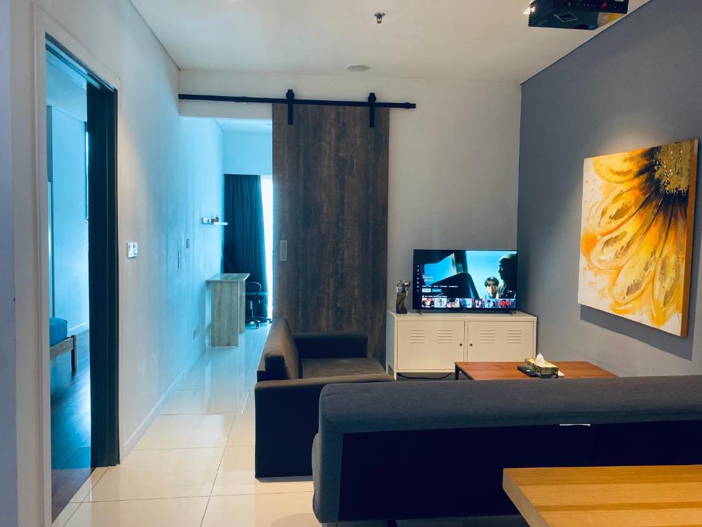 een woonkamer met een bank en een televisie bij Apartment near KLCC by GRIHOZ in Kuala Lumpur