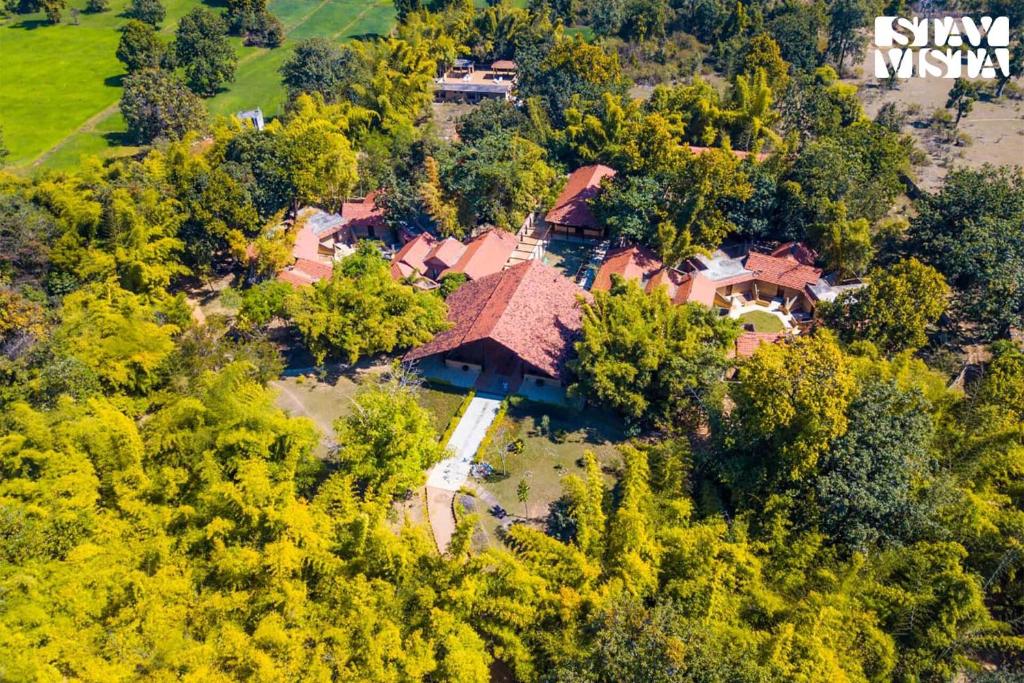 una vista aérea de una casa en el bosque en StayVista's Rustic Respite - Hillside Retreat near Tala Gate with Swimming Pool, Lawn & Indoor-Outdoor Games, en Tāla