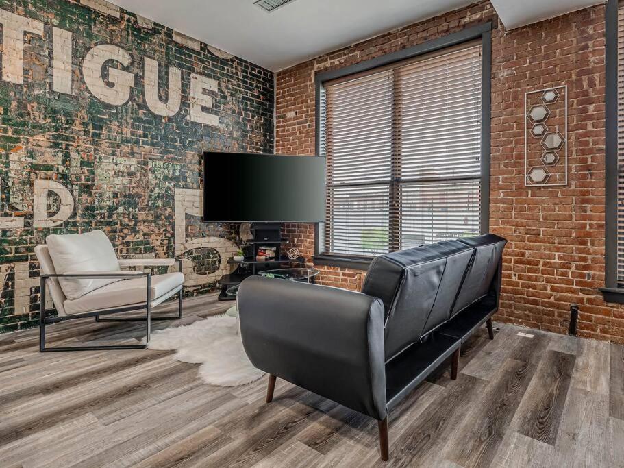 a living room with a couch and a tv at Deluxe Studio in Historic Downtown Building! in Bartlesville