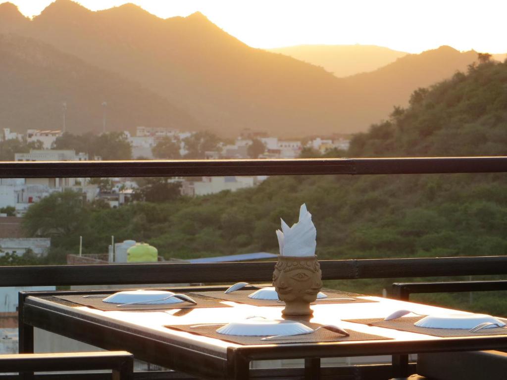 una mesa en un balcón con vistas a las montañas en Omkar Palace, en Udaipur