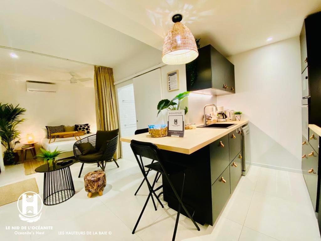 - une cuisine avec un comptoir et des chaises dans la chambre dans l'établissement Les Hauteurs de la Baie, à Nouméa