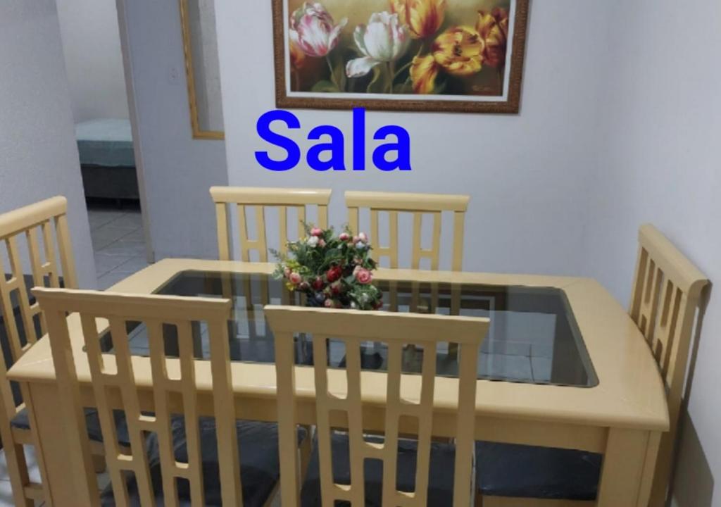 una mesa de madera con sillas y un letrero que dice saa en Doce Lar, en Peruíbe