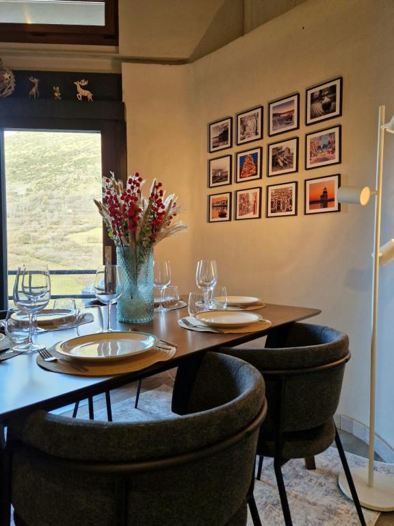 una sala da pranzo con tavolo, sedie e finestra di Tuca - Cozy Duplex with Private Parking Betren - Vielha a Vielha