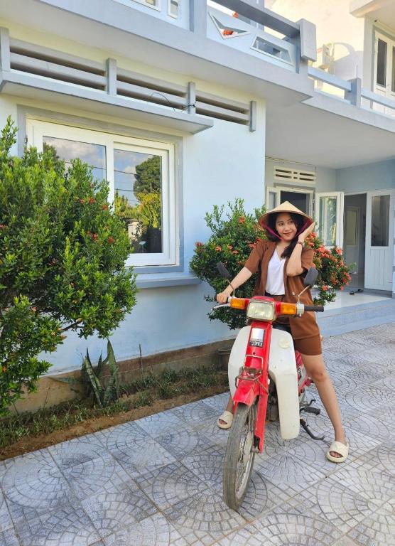 a woman is sitting on a motor bike at YÊN Homestay in Dien Ban