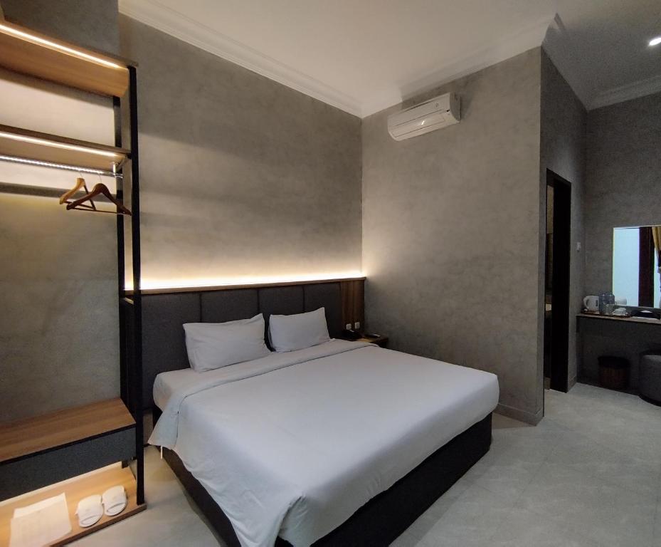 Postel nebo postele na pokoji v ubytování The Grand Palace Hotel Malang