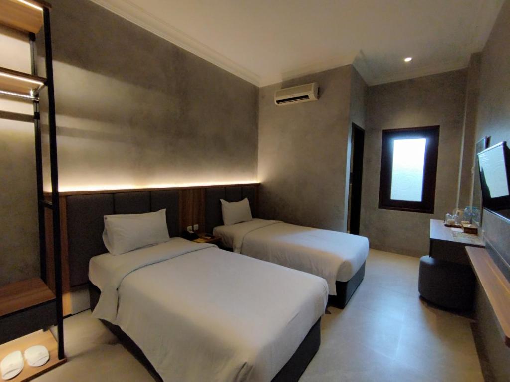 Postel nebo postele na pokoji v ubytování The Grand Palace Hotel Malang