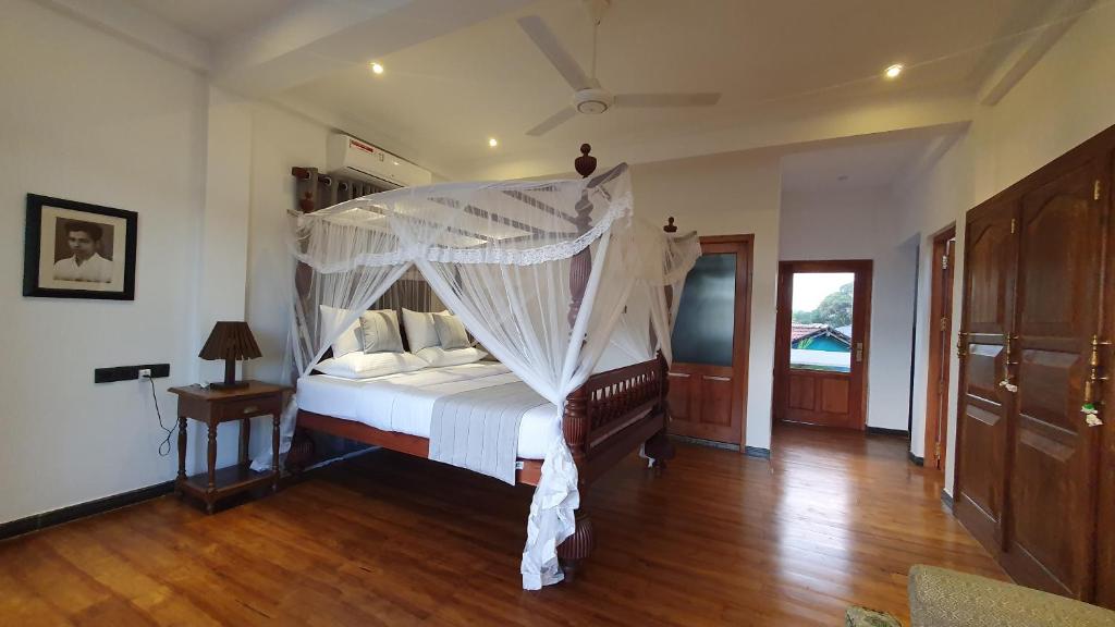 um quarto com uma cama de dossel em Margaret House em Mirissa