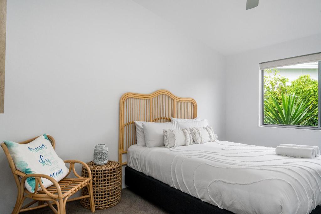 1 dormitorio con 1 cama, 1 silla y 1 ventana en Byron Bay Holiday Homes - Marie and Fred's Villa, en Byron Bay