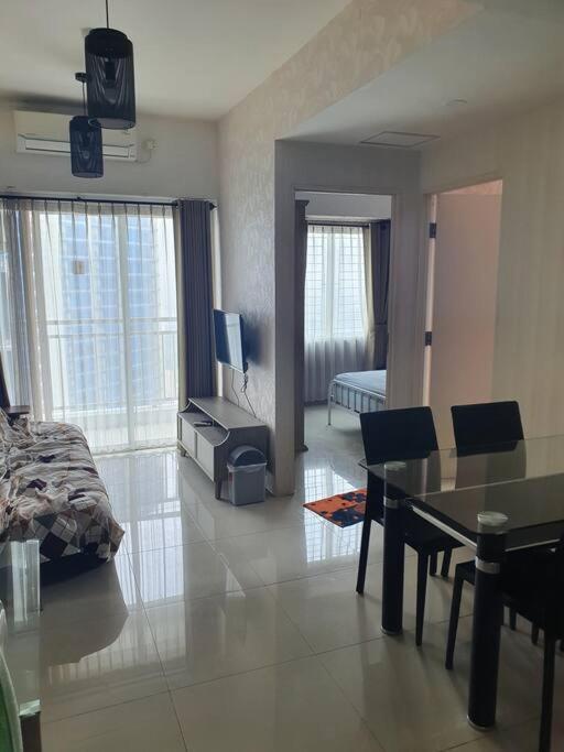 a living room with a bed and a dining room at Apartement orchard Surabaya in Surabaya