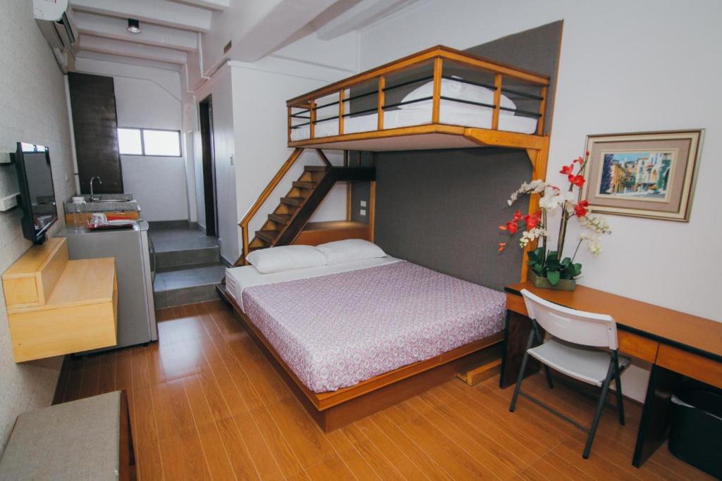 a bedroom with a bunk bed and a desk with a desk at Amaris Bed & Breakfast in Mactan