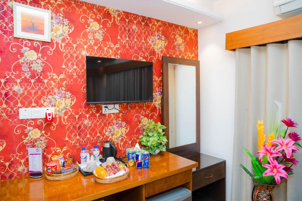 a room with a red wall with a mirror at Hotel Air Inn Ltd - Airport View in Dhaka