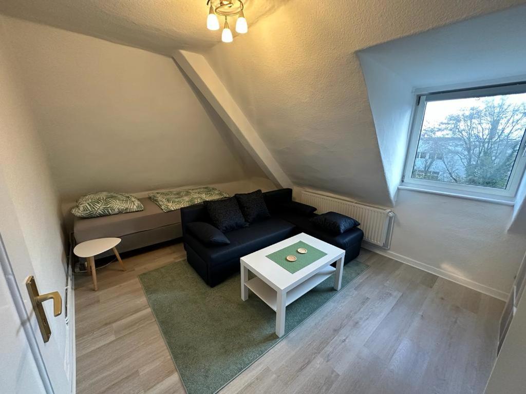 een woonkamer met een bank en een raam bij Dachwohnung in ruhiger Lage in Hannover
