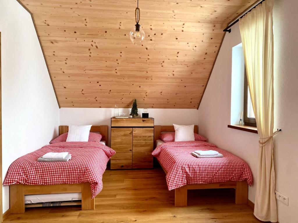 two twin beds in a room with wooden ceilings at Chata pod horou in Stará Lesná