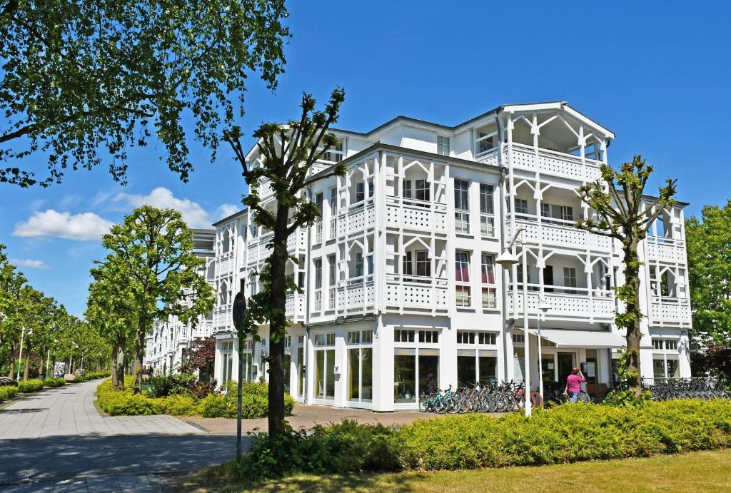 a large white building with trees in front of it at Ferienwohnung im Seepark mit Balkon 714 Sommerwind in Ostseebad Sellin