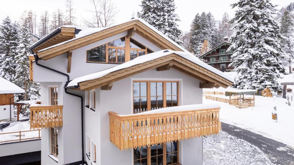 ein Haus mit einer Terrasse im Schnee in der Unterkunft Chalet Marmotta CULM - Luxus Chalet Ski-In Ski-Out in Sankt Anton am Arlberg