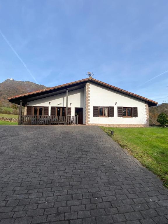 a white building with a driveway in front of it at Casa Rural Laurenea in Alzate