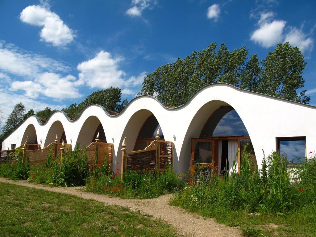 ein weißes Gebäude mit gebogenem Dach in der Unterkunft Gästehaus am Wangeliner Garten in Wangelin