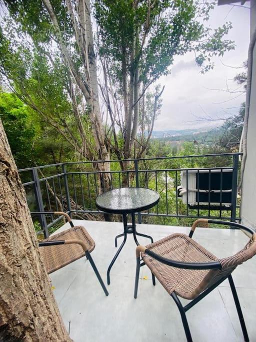 a table and chairs on a balcony with a tree at Garage Hotel - Old Tbilisi in Tbilisi City