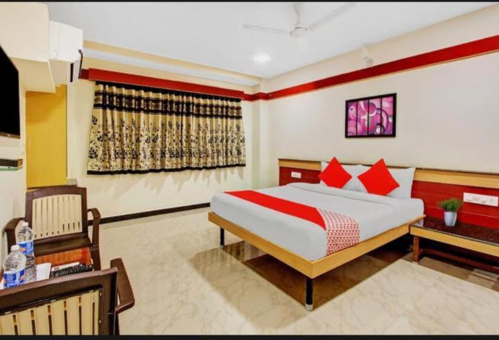 a bedroom with a large bed and a desk and a bed sidx sidx at sri sai guru comfors in Bangalore