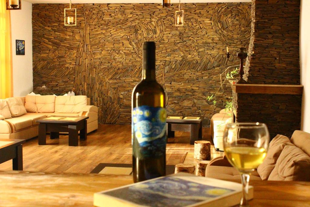 a bottle of wine sitting on a table with a glass at Hotel Starry Night in Stepantsminda