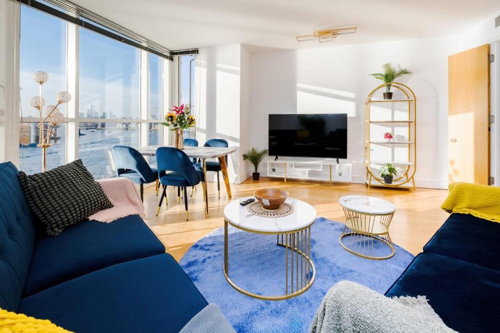ein Wohnzimmer mit einem blauen Sofa und einem Tisch in der Unterkunft Riverview 2 Bedroom and 2 Bath Apartment in London