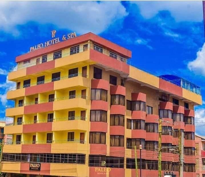 a large building with a hotel sign on top of it at Paleo Hotel and Spa in Thika