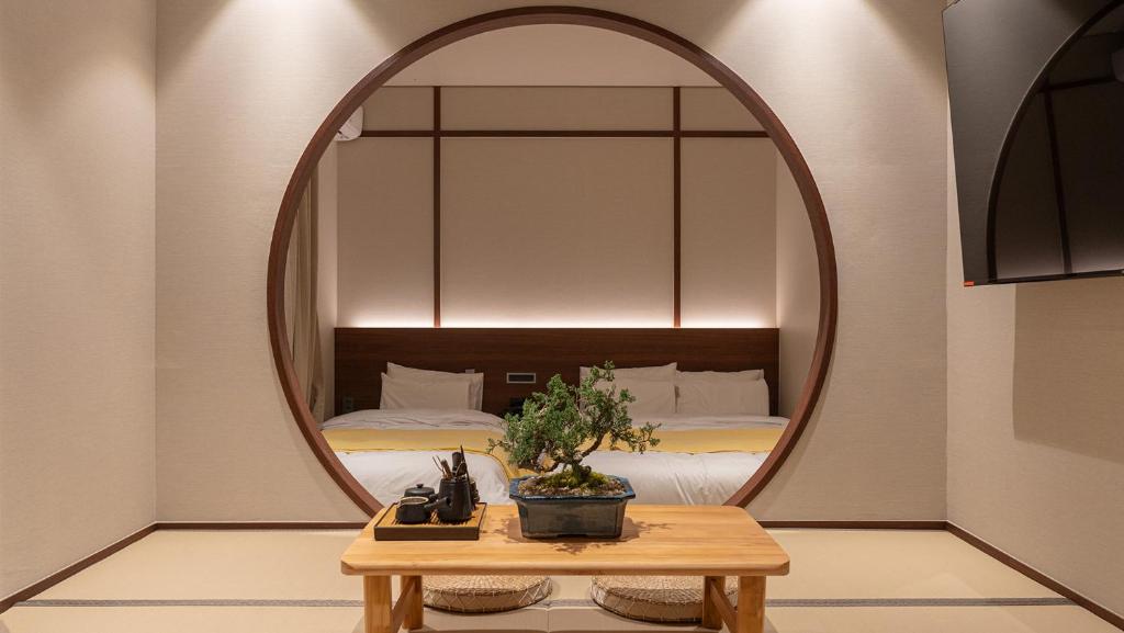 a mirror in a room with a bed and a table at Annk Ryokan Yosuriguri Hotel in Cheonan