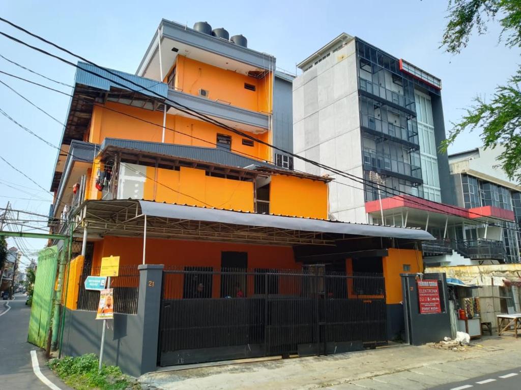 an orange building on the side of a street at Penginapan 21 By SPAZIE in Jakarta