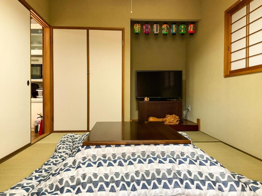 minpaku hotaru - Vacation STAY 65549v في تاكاماتسو: غرفة معيشة مع سرير وتلفزيون