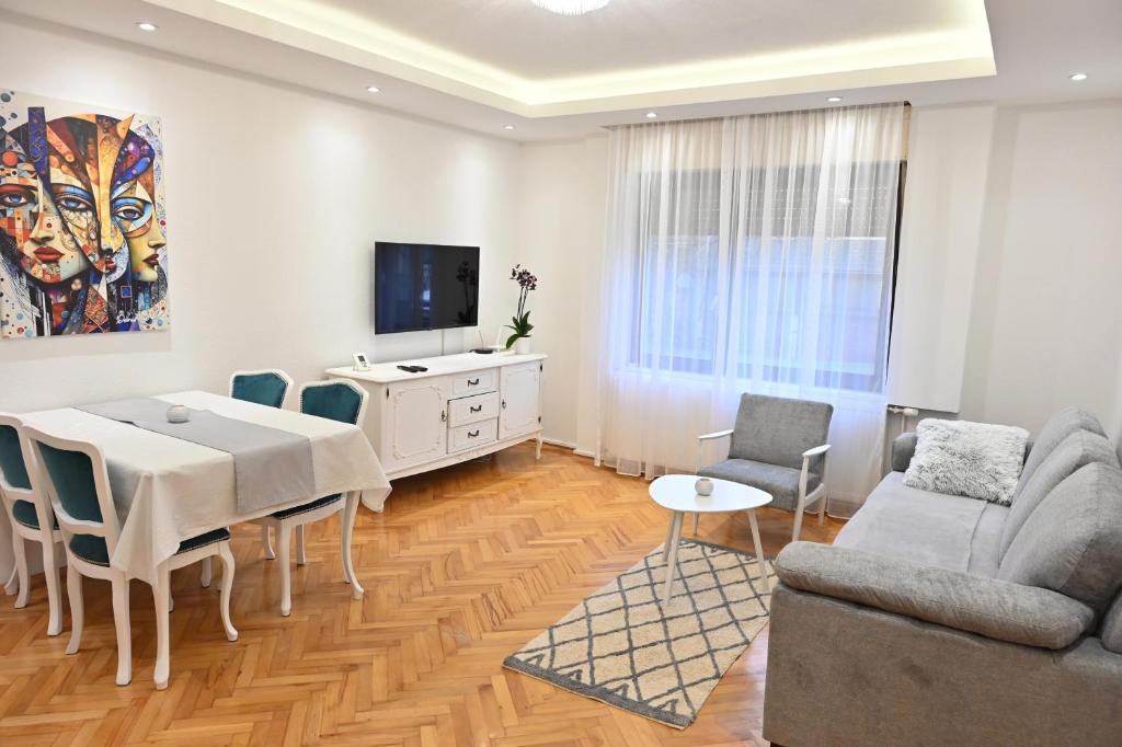 a living room with a dining table and a tv at Apartman Felix in Laktaši