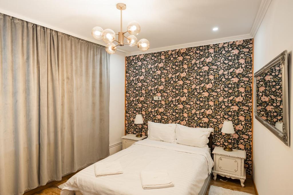 ein Schlafzimmer mit einem Bett und einer Blumenwand in der Unterkunft Apollonia eState OLD TOWN BIG AND LUXURIOUS in Braşov