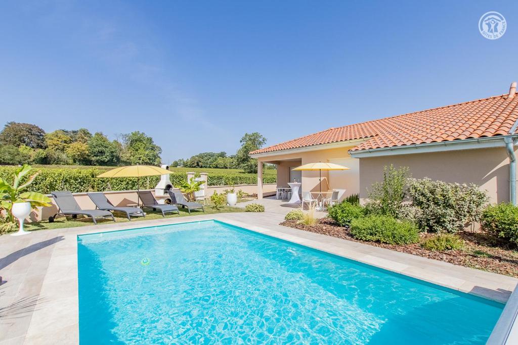 a swimming pool in the backyard of a house at Le Mâconnais Guest House in Vinzelles