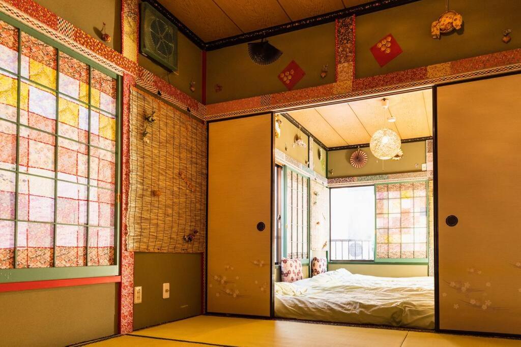 ein Zimmer mit einer offenen Tür und einem Bett darin in der Unterkunft I LOVE HANEDA in Tokio