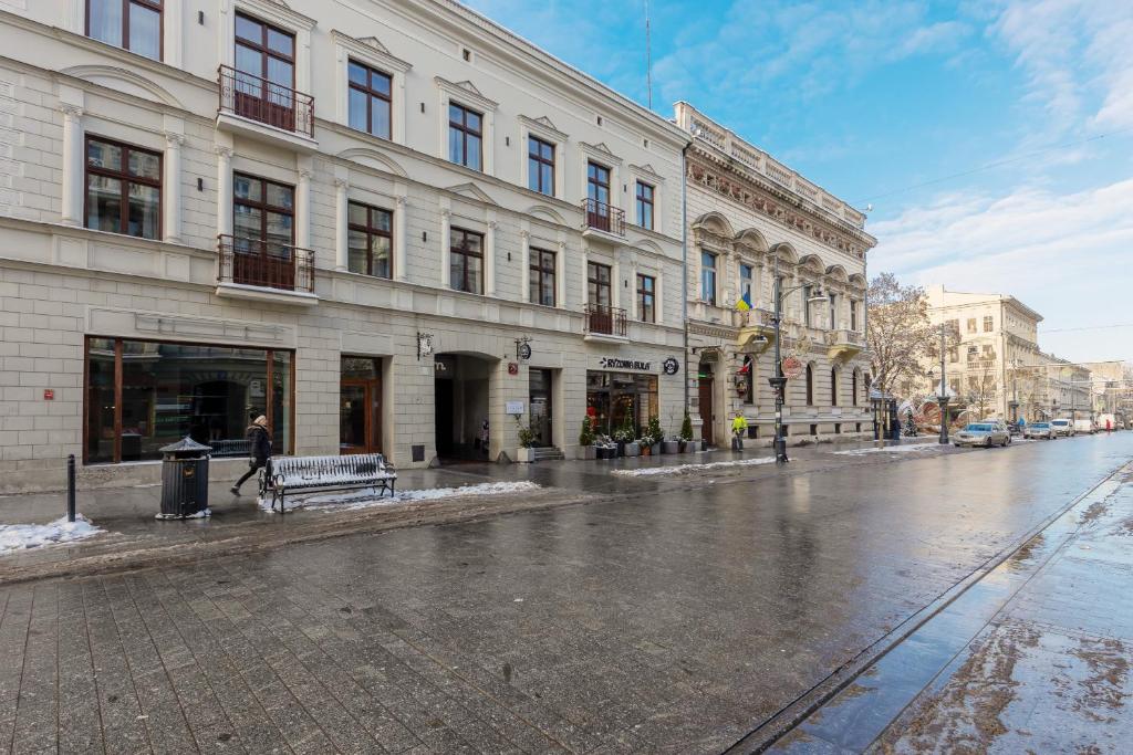 a person walking down a street in front of a building at Beautiful Studios Piotrkowska by Renters in Łódź