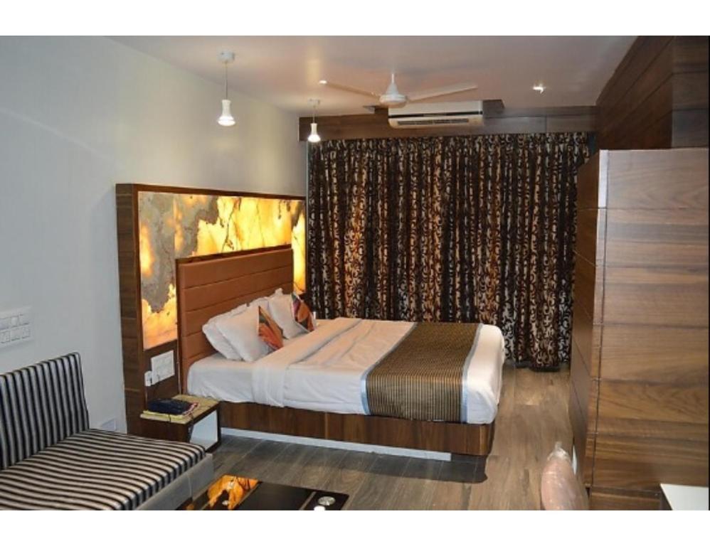 a bedroom with a bed and a couch at Hotel Relax Inn, Surat, Gujarat in Surat