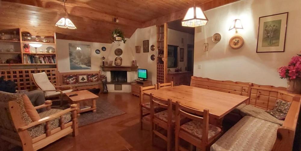 sala de estar con mesa de madera y sillas en Appartamento a Francolini, en Folgaria