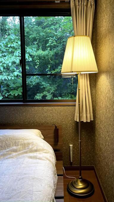 Postel nebo postele na pokoji v ubytování 庭付き和モダン平屋の一棟貸し 居庵 iori-ori 小さな森に住む