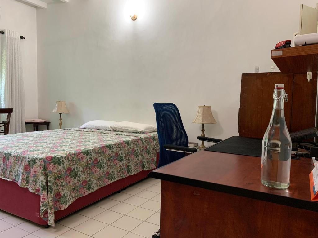 a bedroom with a bed and a bottle on a table at The Sheltuh : Closer to everything Colombo in Manning Town